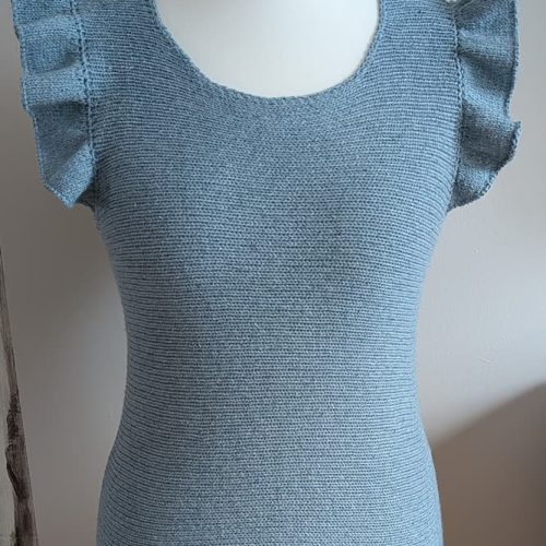 Blue ruffle top with soft shoulder ruffles on a white mannequin, front view