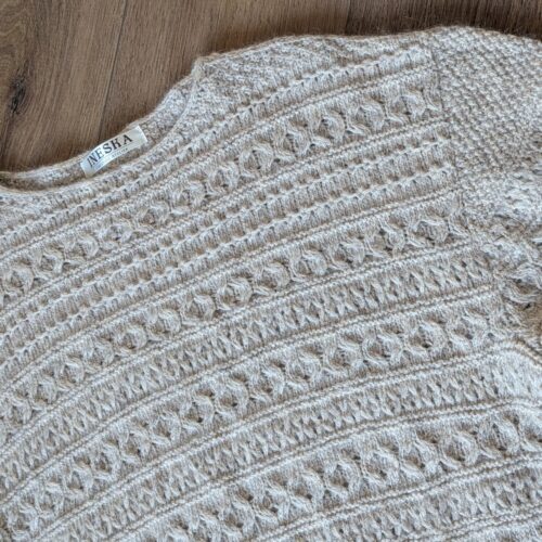 Close-up of handknitted baby alpaca lace texture in natural beige tones — INESKA Soul Song Sweater
