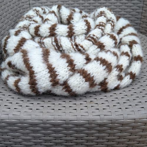 Soft cream alpaca scarf by INESKA — draped on a woven chair, natural undyed cream and brown