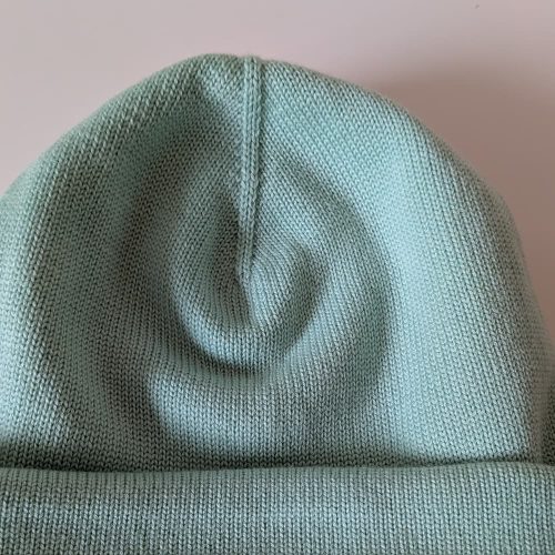 Close-up of a mint green 100% merino wool beanie showing the double-layer knit and ribbed cuff
