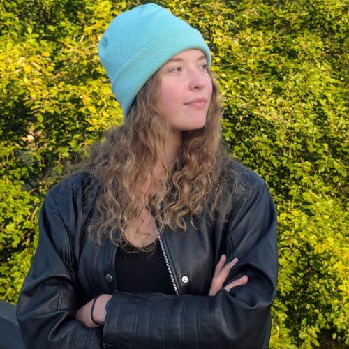 Side view of a mint merino wool beanie worn slouchy with a plaid shirt