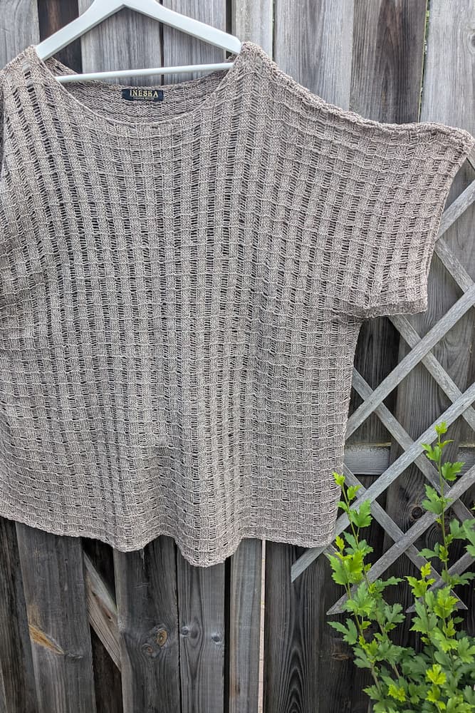 Full front view of the hemp knit tunic on a hanger, boxy silhouette with short sleeves, beige-brown mélange