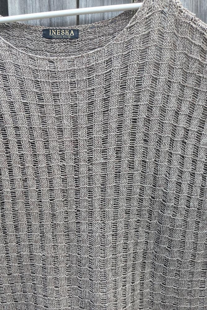 Close-up of hemp tunic neckline with INESKA Creative Atelier label, openwork knit in beige-brown mélange